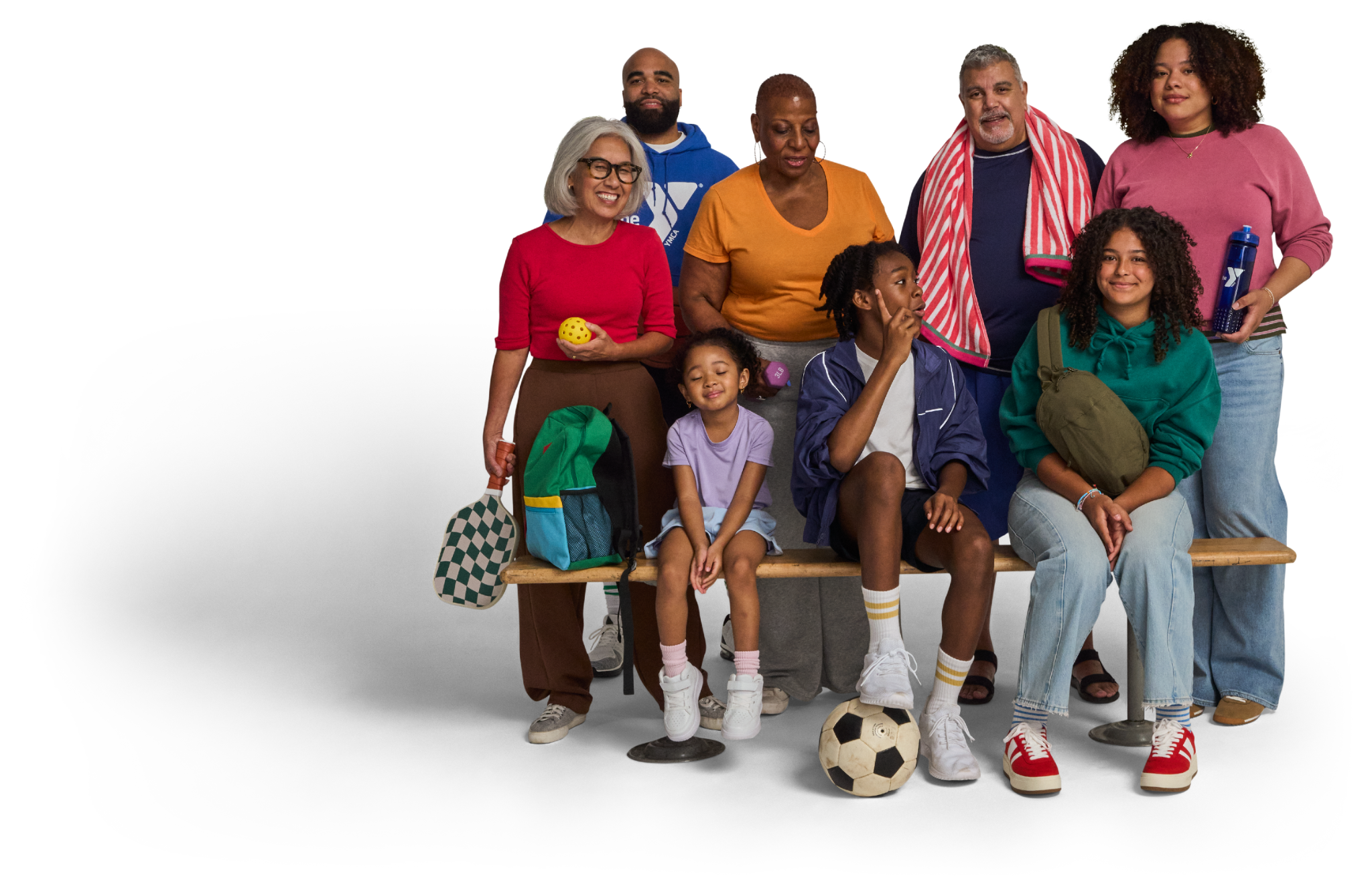 A multigenerational YMCA family gathered with sports and recreation equipment